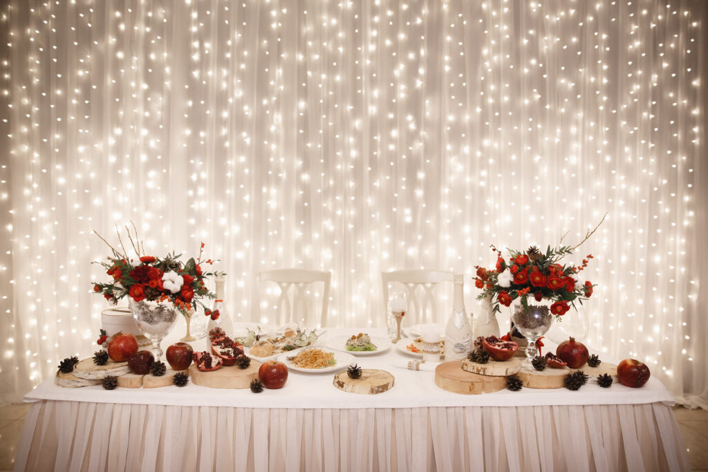 Wedding decorations, a table of the bride and groom, in the background illumination from wedding garlands. Winter Wedding Concept